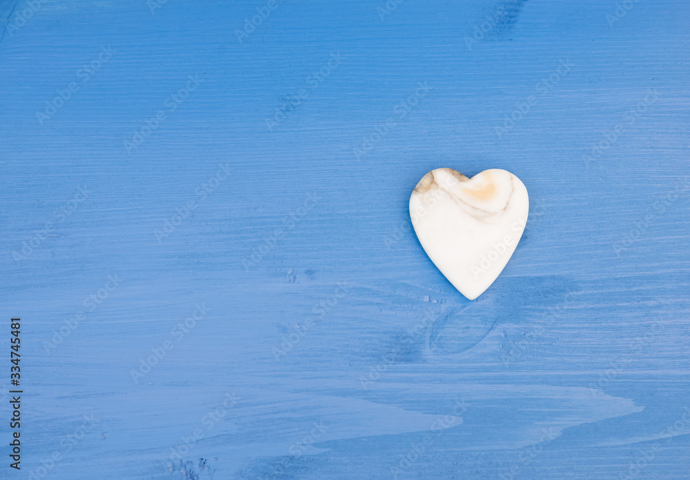 Fototapeta premium Valentine background. Marble Heart on an blue wooden table. Copy space