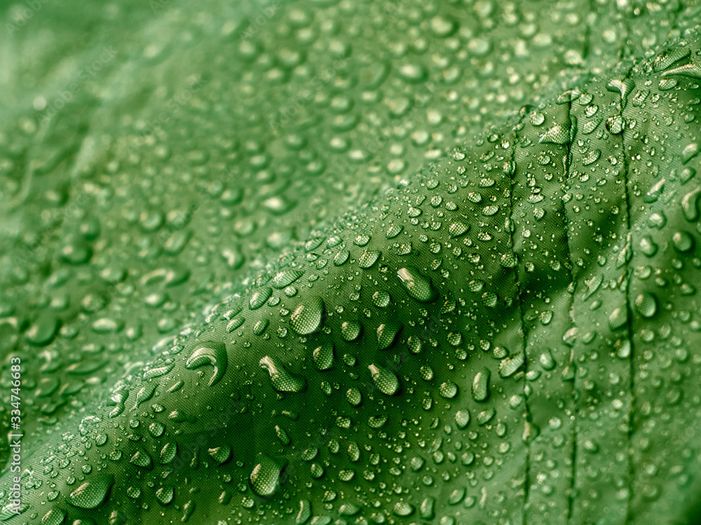 Green waterproof fabric with water drops.
