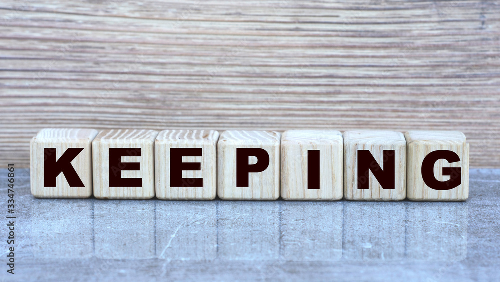 Fototapeta premium KEEPING , the word on the cubes on a gray marble background. Business concept