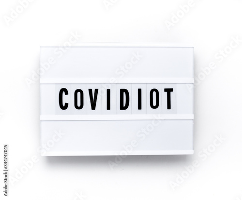 Sign - COVIDIOT on light box, Covidiot is new name for shaming ignorant coronavirus reactions