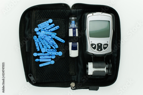Glucometer and other supplies shot from above in a flat lay arrangement. Isolated on a while background. 
