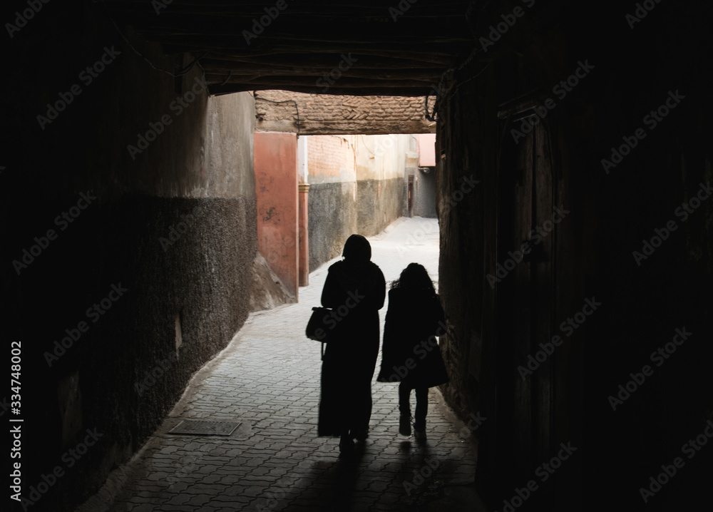 Siluetas de personas caminando por un callejón en Marrakech