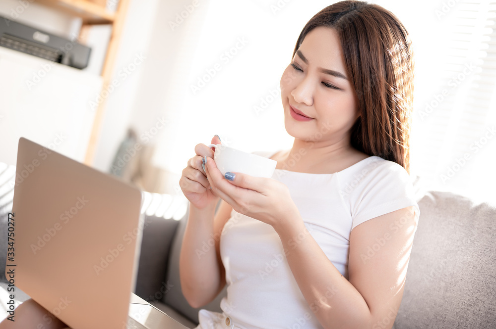 Beautiful young asian woman in white t-shirt working from home with laptop in sunshine background by video call meeting online app. Remote communication, self quarantine prevent coronavirus concept. Beautiful young asian woman in white t-shirt working from home with laptop in sunshine background by video call meeting online app. Remote communication, self quarantine prevent coronavirus concept.