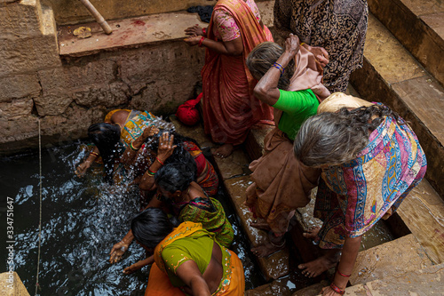 Slika na platnu Indian women bathing and washing with water in Varanasi