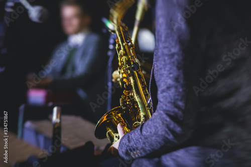 Concert view of a female saxophonist,  professional saxophone player with vocalist and musical during jazz band performing music