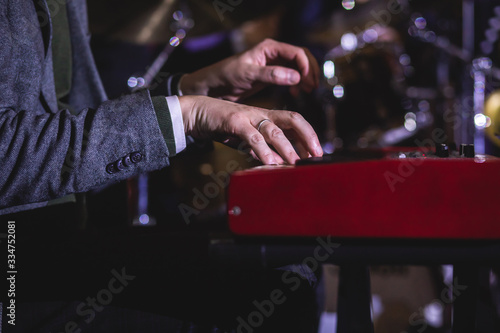Concert view of a musical keyboard piano player during musical jazz band orchestra performing  keyboardist hands during concert  male pianist on the stage