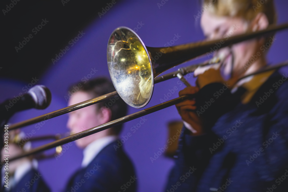 Fototapeta premium Concert view of a trombone player trombonist with musical jazz band performing in the background