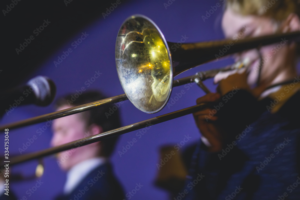 Fototapeta premium Concert view of a trombone player trombonist with musical jazz band performing in the background