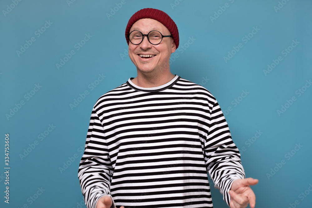 Naklejka premium Young attractive caucasian man in red hat and striped clothes laughing