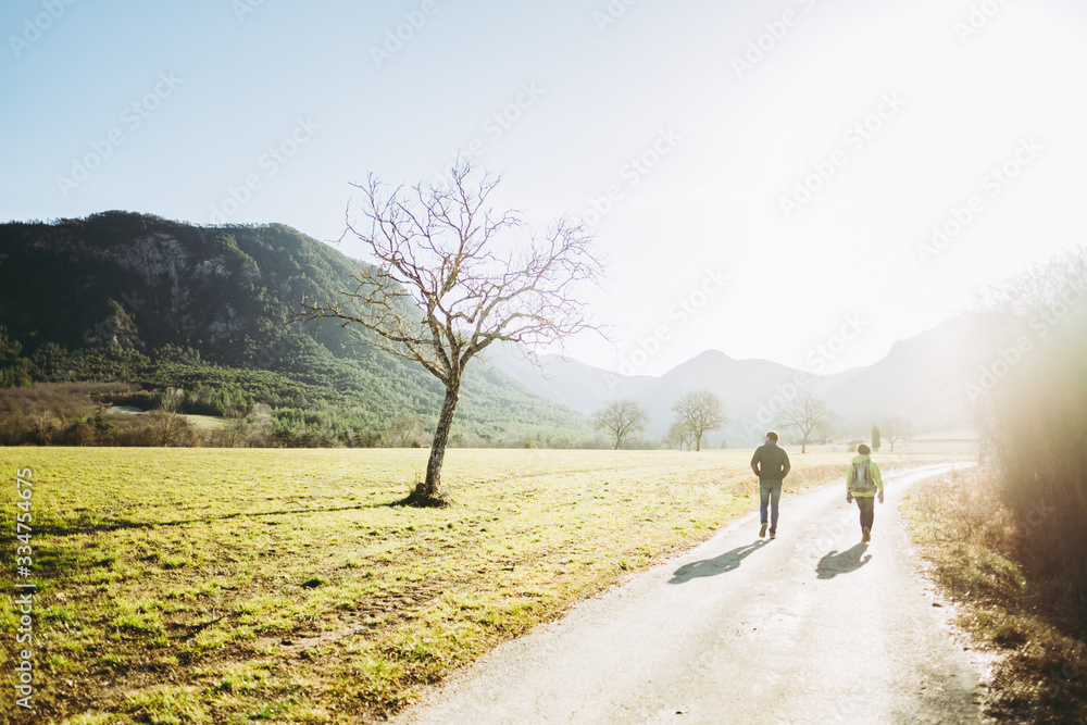 Deux randonneurs de dos en train de marcher dans un paysage montagneux