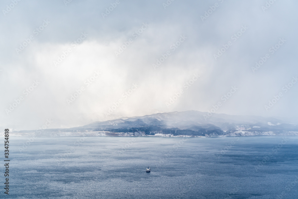 Boat crossing the sea in winter. Cloudy and misty day in Hakodate, Japan