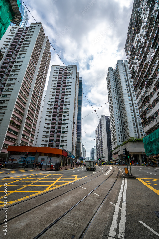 Fototapeta premium Road and high buildings in Quarry Bay in Hong Kong. Rail tracks on the ground.