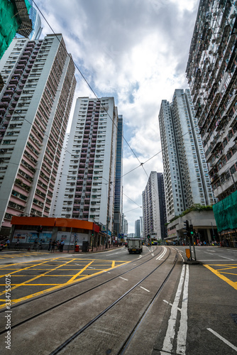 Road and high buildings in Quarry Bay in Hong Kong. Rail tracks on the ground.