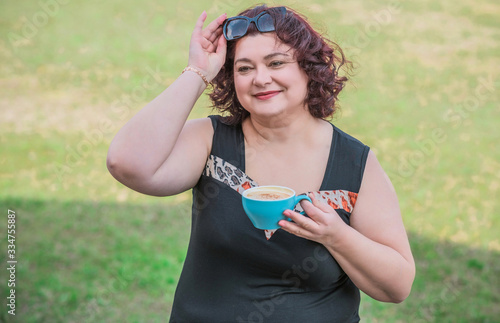 Happy mature plus size women with cup of coffee 