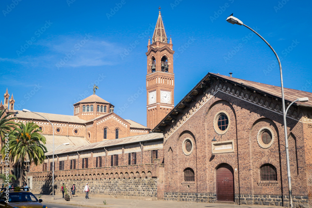 Asmara, Eritrea - November 01, 2019: Facade View to the Church of Our Lady of the Rosary and Palm Trees