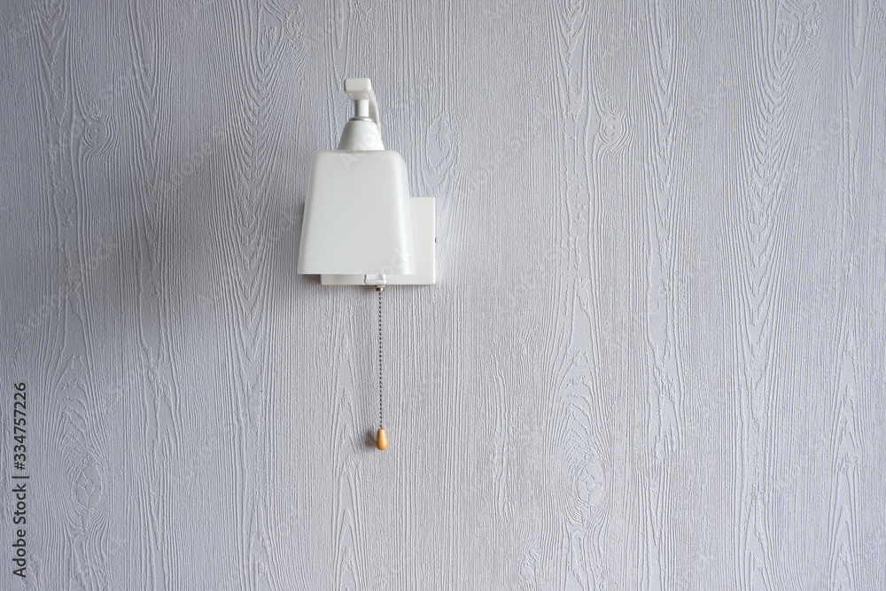 Minimalistic, stylish, white wall lamp on a blue wall. Stylish interior. Coziness.