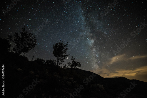 Colorful night landscape Milky Way over the mountains in the starry sky with hills in summer.