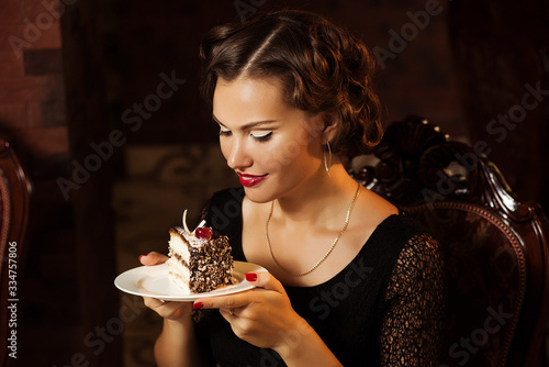 Pretty woman holding plate with dessert. Attractive european girl looking at cake.