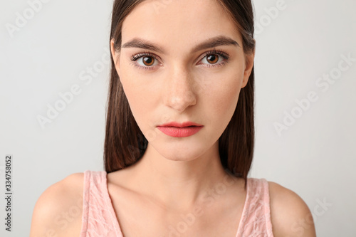 Young woman with beautiful makeup on light background