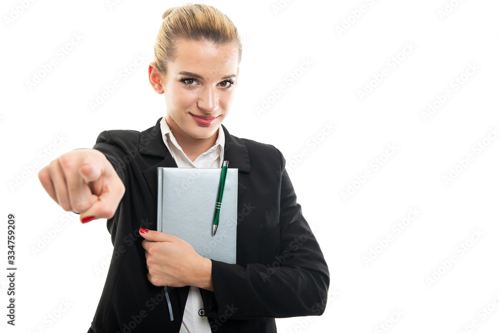 Young female assistant manager holding agenda pointing camera Young female assistant manager holding agenda pointing camera