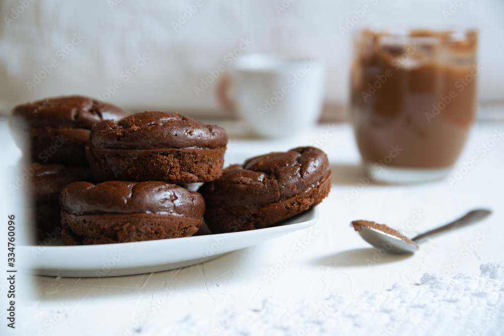 Home made chocolate muffins served on a rustic kitchen next to some cups with coffee and tea. Empty copy space for Editor's text. Home made chocolate muffins served on a rustic kitchen next to some cups with coffee and tea. Empty copy space for Editor's text.