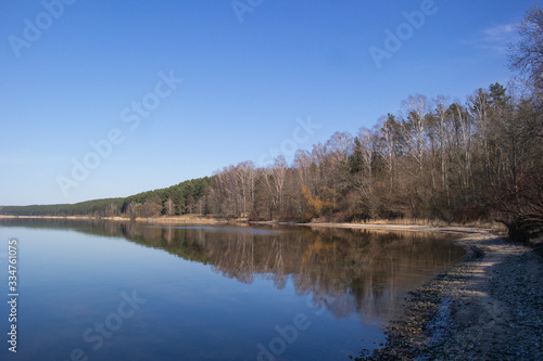 Mixed forest by the lake in early spring. The beginning of spring in the northern countries.