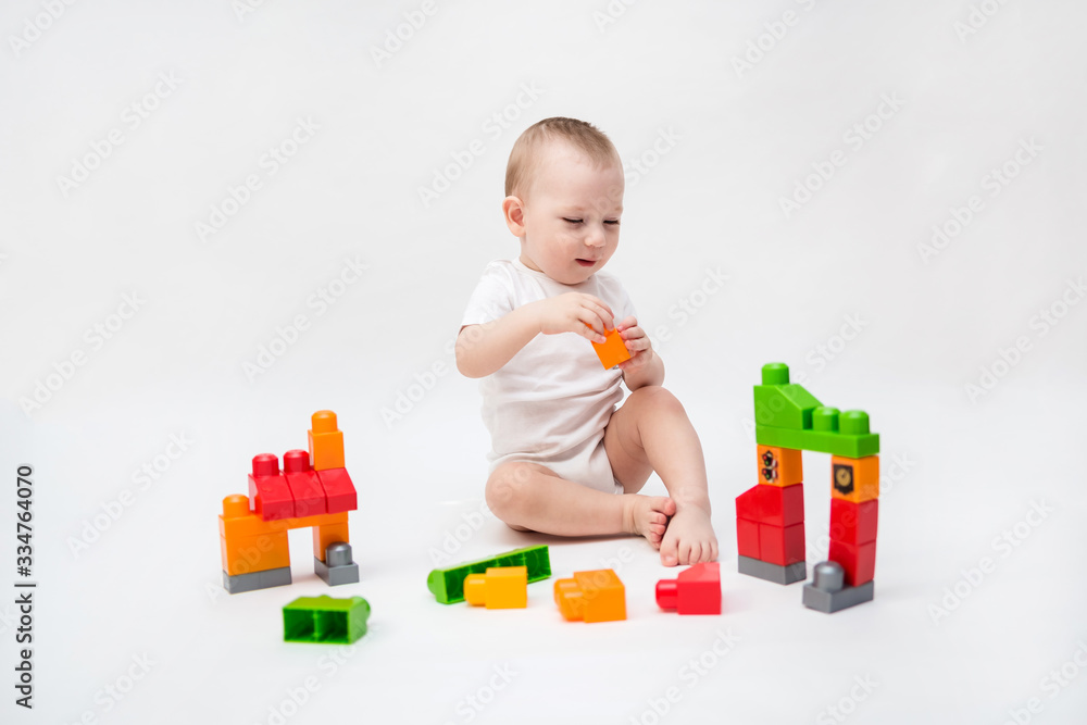 On white background with copy space. The little kid plays the constructor. game,education On white background with copy space. The little kid plays the constructor. game,education