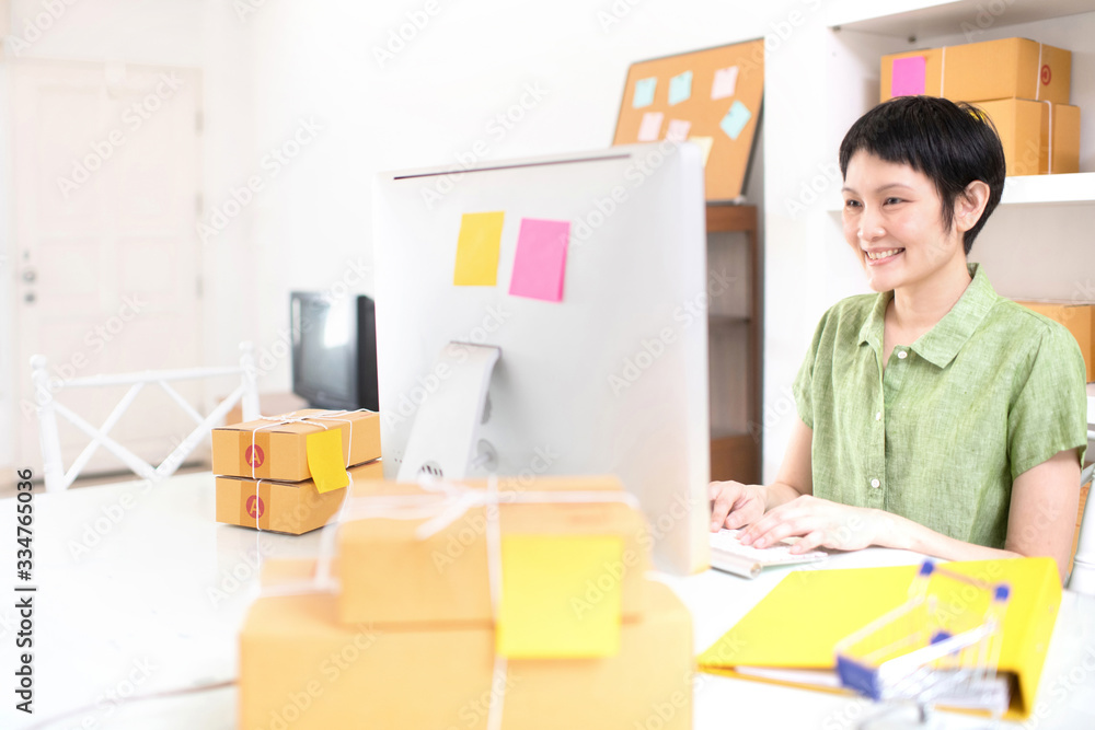 Asian on line business owner with computer and cardboard box ready for shipping,working on social media and communication, Successful on line business. work from home concept Asian on line business owner with computer and cardboard box ready for shipping,working on social media and communication, Successful on line business. work from home concept