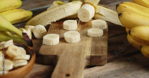 Slices of fresh banana on the cutting Board and the bowl rotate slowly.