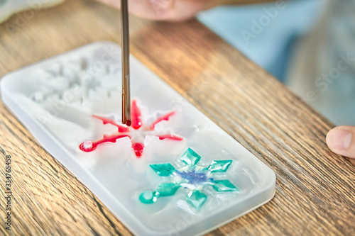 Pouring red resin into star shaped resin mold , process of prepare for make an accessories