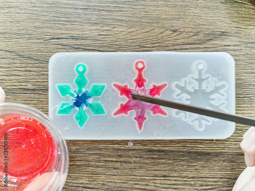 Pouring red resin into star shaped resin mold , process of prepare for make an accessories