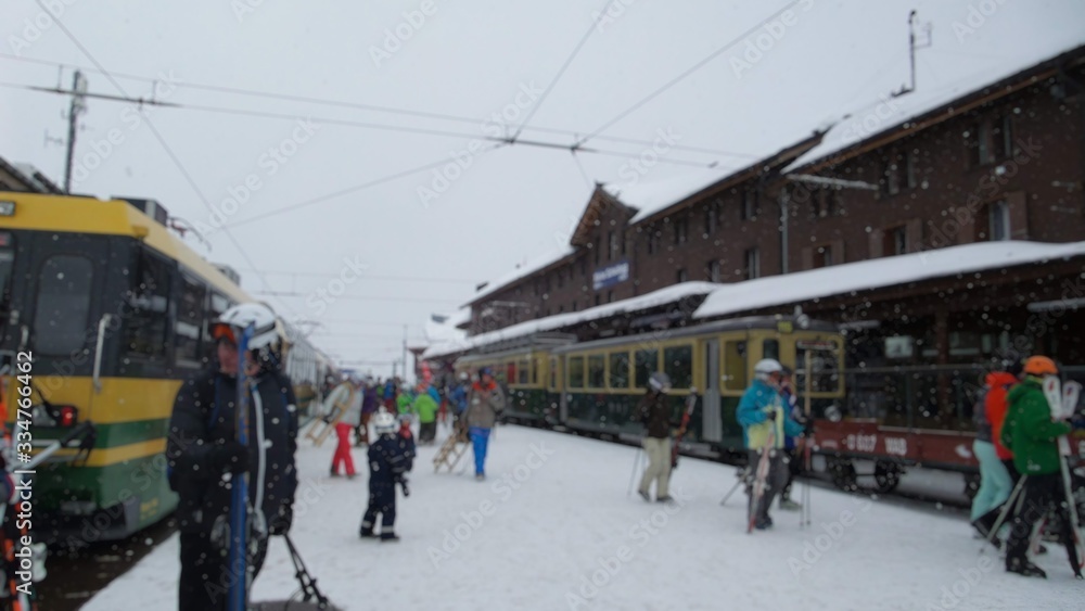 Blurred abstract background of crowds and trains in Europe's ski destinations in winter while snow falls.          