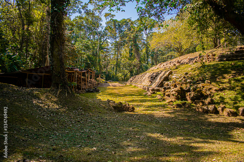 mayan ruin of takalik abaj, ancient temple and steps built with stones, with huge forest and plants around photo