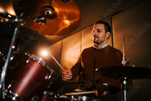 Low angle image of a drummer playing indoors.