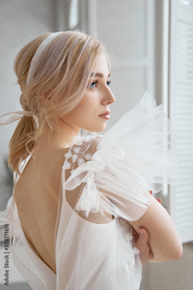 Luxurious white wedding dress on the girl's body. New collection of wedding dresses. Morning bride, a woman waiting for the groom before the wedding ceremony. Young bride in a long dress Luxurious white wedding dress on the girl's body. New collection of wedding dresses. Morning bride, a woman waiting for the groom before the wedding ceremony. Young bride in a long dress