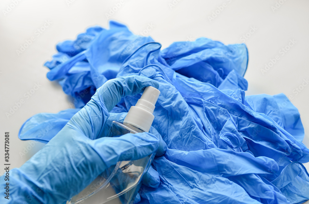 Fototapeta premium Disposable latex gloves in blue. Antiseptic in a transparent flocon.