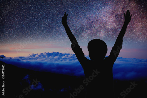 Woman enjoying starry night with arms wide open.