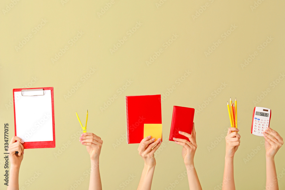 Many hands with school supplies on color background Many hands with school supplies on color background