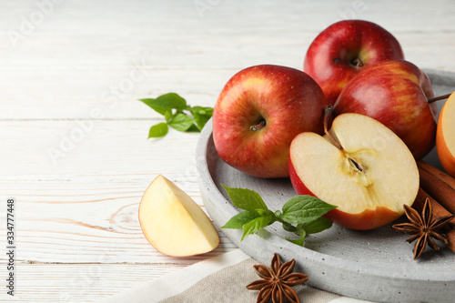 Tray with apple and cinnamon, and towel on wooden background, close up