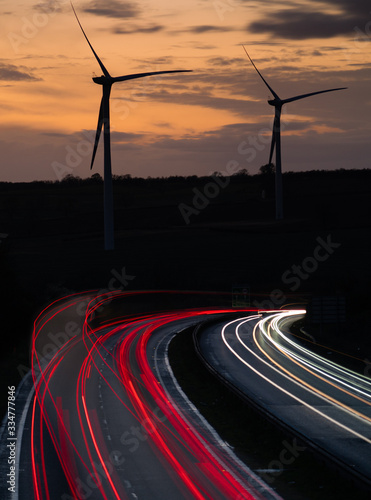 Wind turbines by main road with car light trails