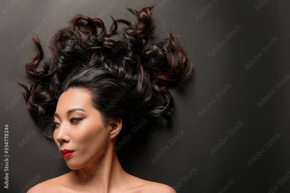Young Asian woman with beautiful hair on dark background Young Asian woman with beautiful hair on dark background