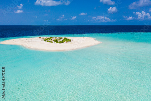 Small tropical island in the lagoon, close to the deep ocean, Maldives. Exotic aerial landscape from seaplane. or drone