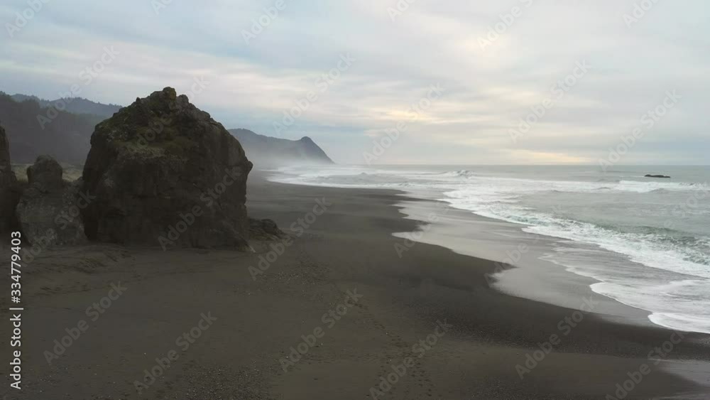 View of Cape Sebastian at sunset from Gold Beach with a bit of color in the clouds and typical coastal fog View of Cape Sebastian at sunset from Gold Beach with a bit of color in the clouds and typical coastal fog