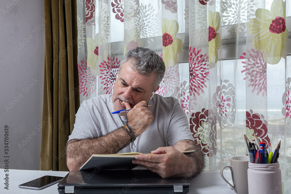 Fototapeta premium Mature man with a beard working at home