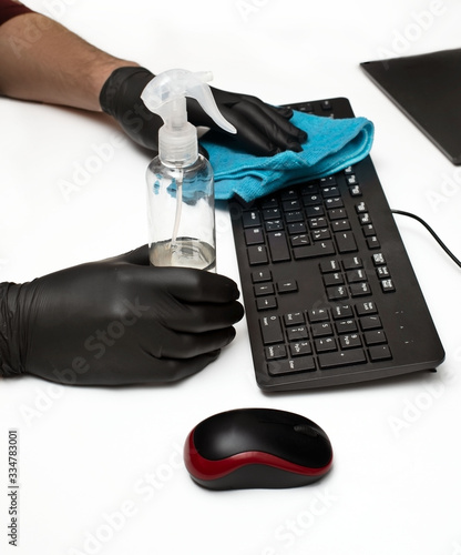hands in protective gloves disinfect the keyboard