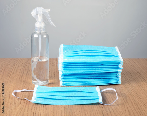 disinfectant and  protective masks stand on the table