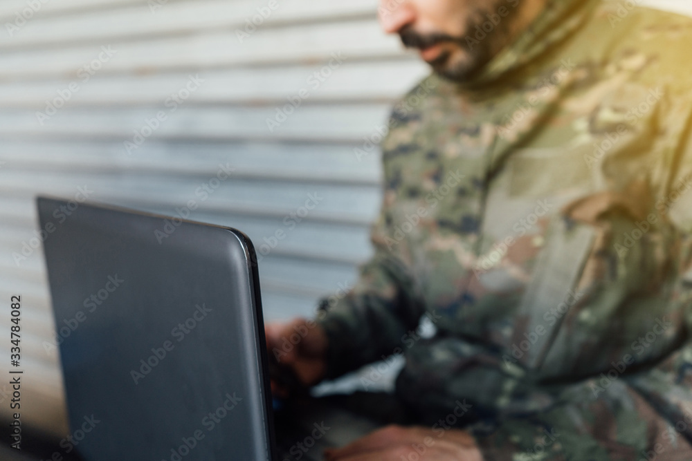 Military detail using a laptop. Pandemic crisis, Spanish soldier. Selective focus.