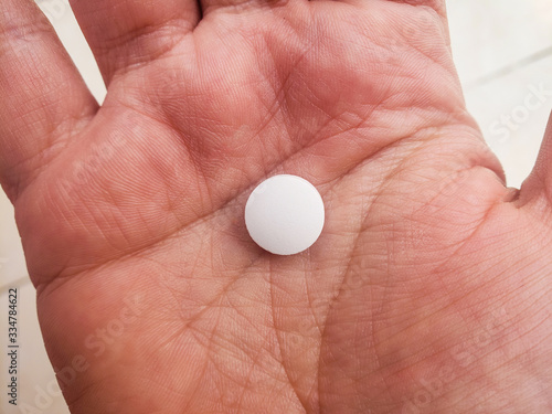 top view of a white pill in hand - health concept