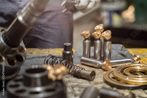 Piston of the hydraulic piston pump on working table, inspection and repair maintenance heavy machinery