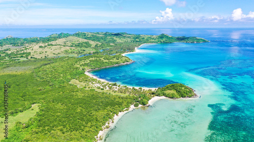 A lagoon with a coral reef and a white sandy beach  aerial drone. The coast of a tropical island. Caramoan Islands  Philippines. Summer and travel vacation concept.